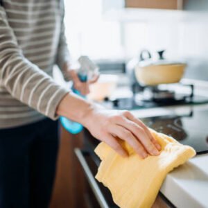 Cropped shot of a young woman cleaning the kitchen counter with cleaning spray and cloth at home during the day