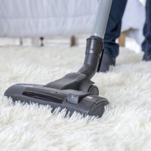 A sellman test vacuuming on a carpet.