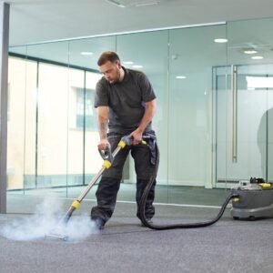 a male cleaning contractor steam cleans an office carpet in a empty office in between tenants.